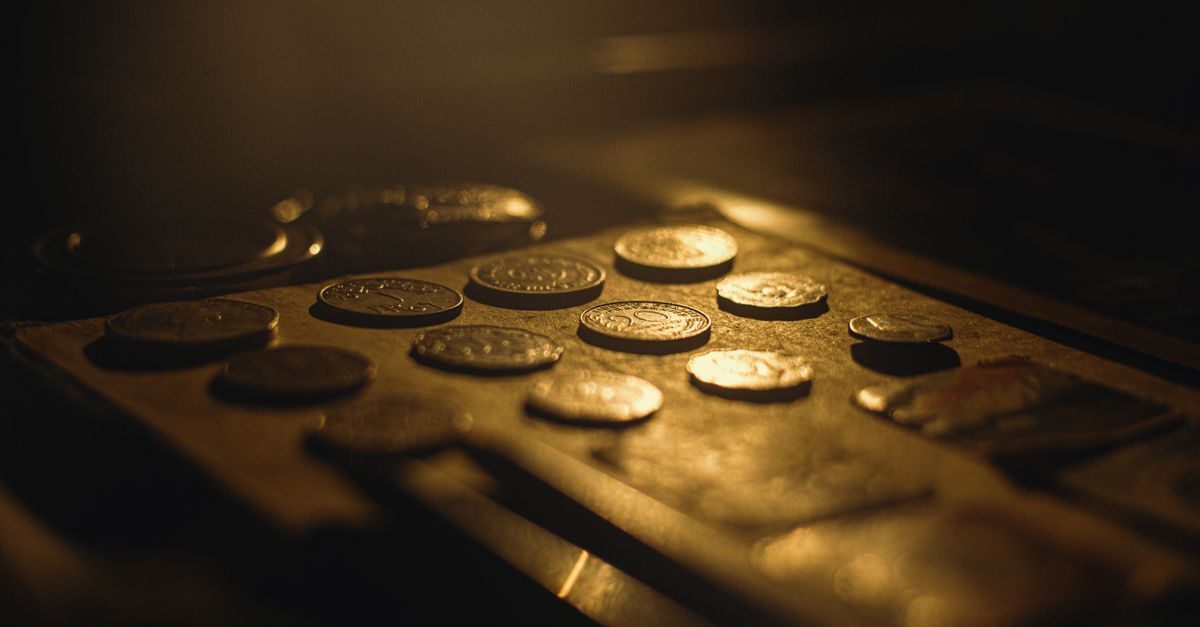 Close-up of vintage coins in warm lighting with artistic shallow focus.