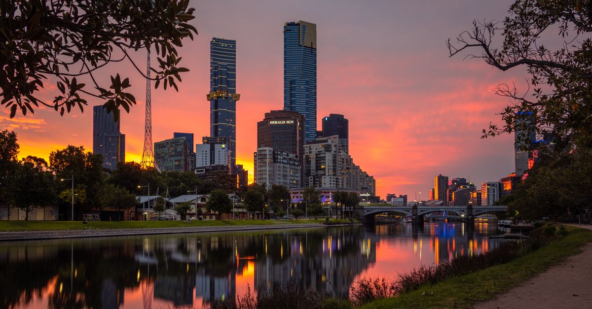 Captivating view of Melbourne's skyline and Yarra River at sunset showcasing vibrant colors and urban reflections.