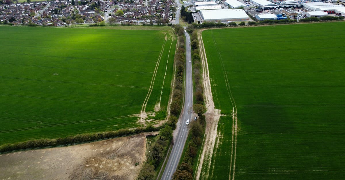 Aerial view of vibrant green farmlands and adjacent road in Central Bedfordshire, UK.