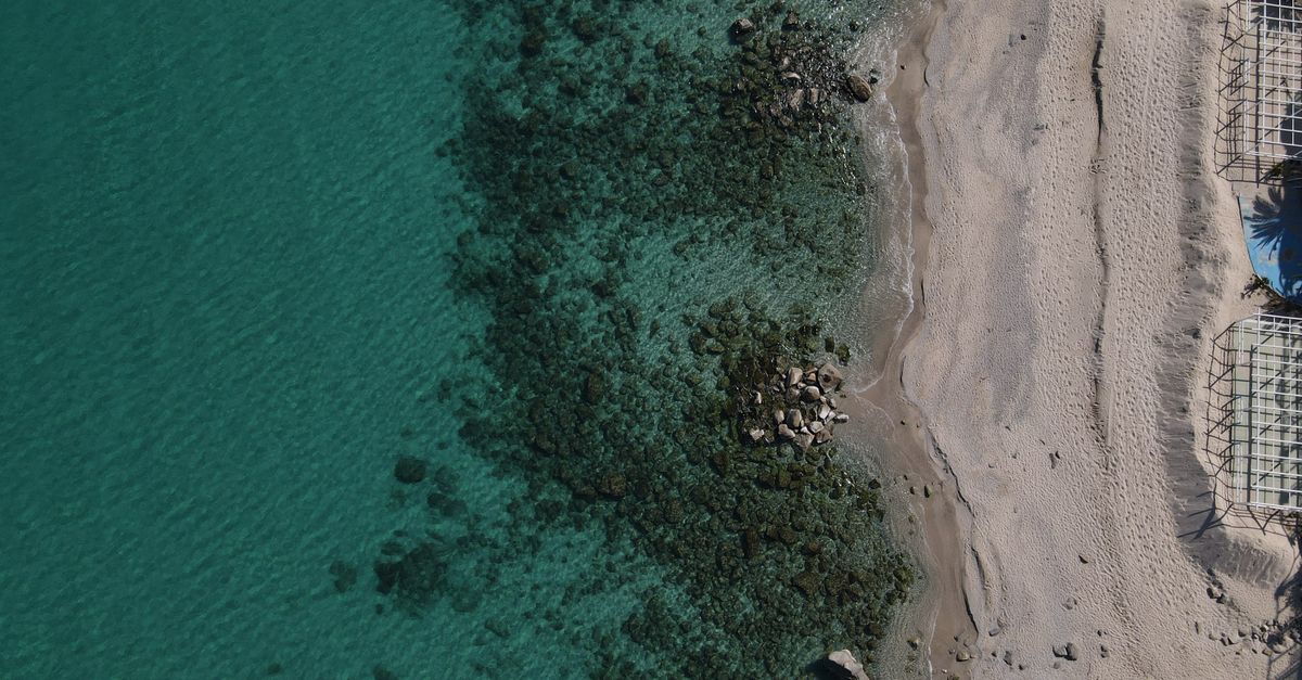 Stunning aerial shot of Soverato beach in Italy, showcasing turquoise waters and sandy shore.
