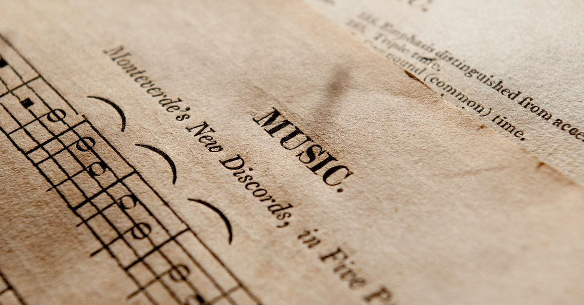 Detailed view of antique music sheets featuring notes and Monteverde's New Discords in sepia tone.