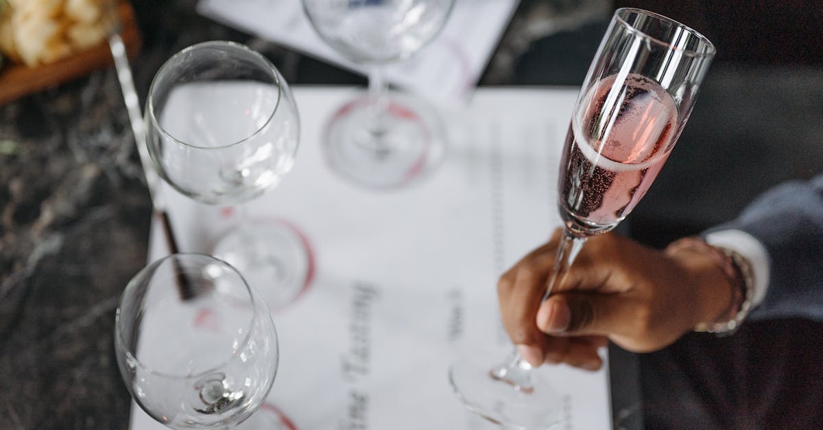 A close-up of a wine tasting setup with glasses and a hand holding champagne.