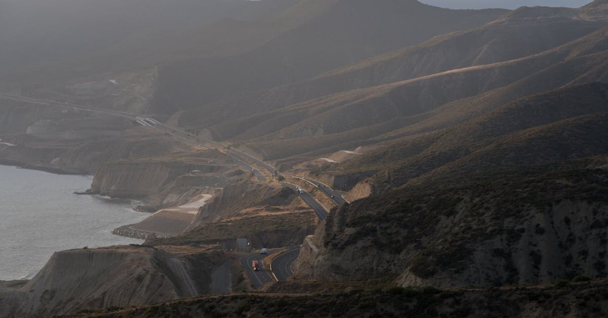 Dramatic aerial view of winding coastal roads through Guadalupe's hills at dusk.