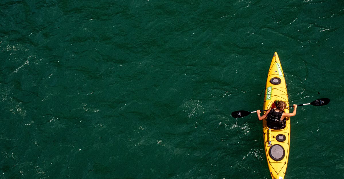 Dynamic aerial image of a woman kayaking through vibrant turquoise waters, perfect for adventure themes.