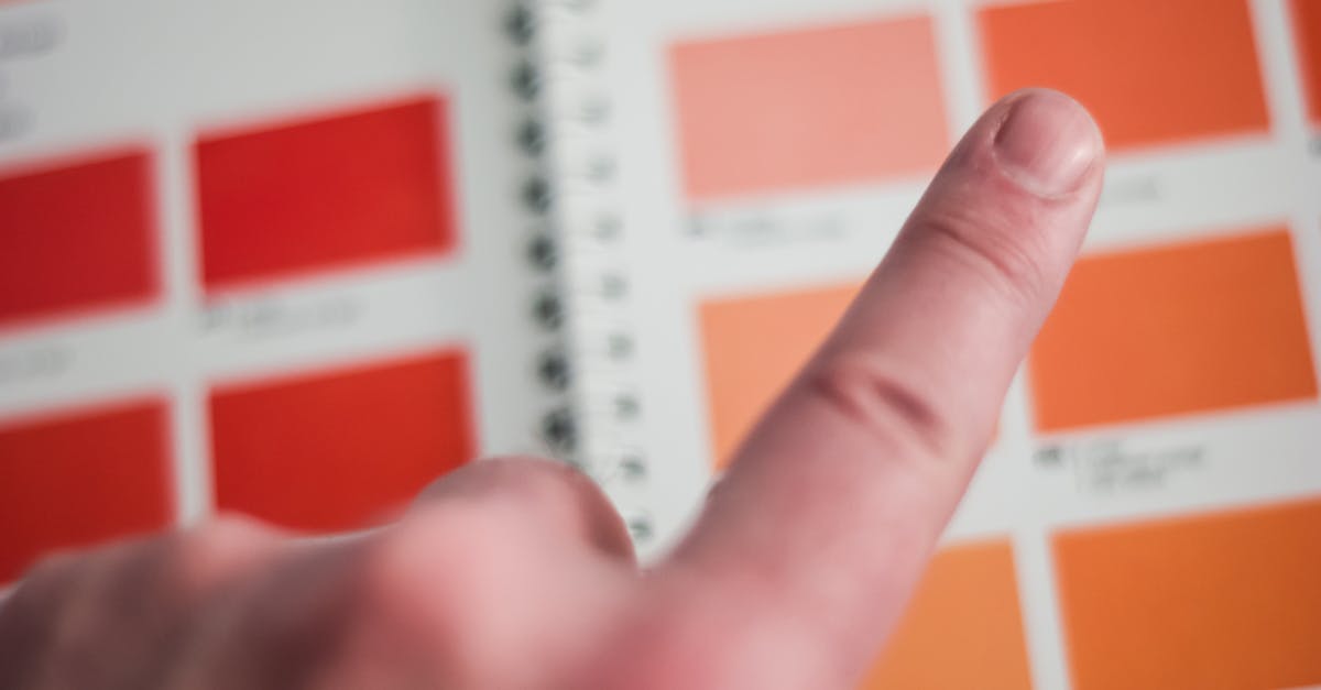 A finger points at a color swatch on a vibrant palette inside an office environment.